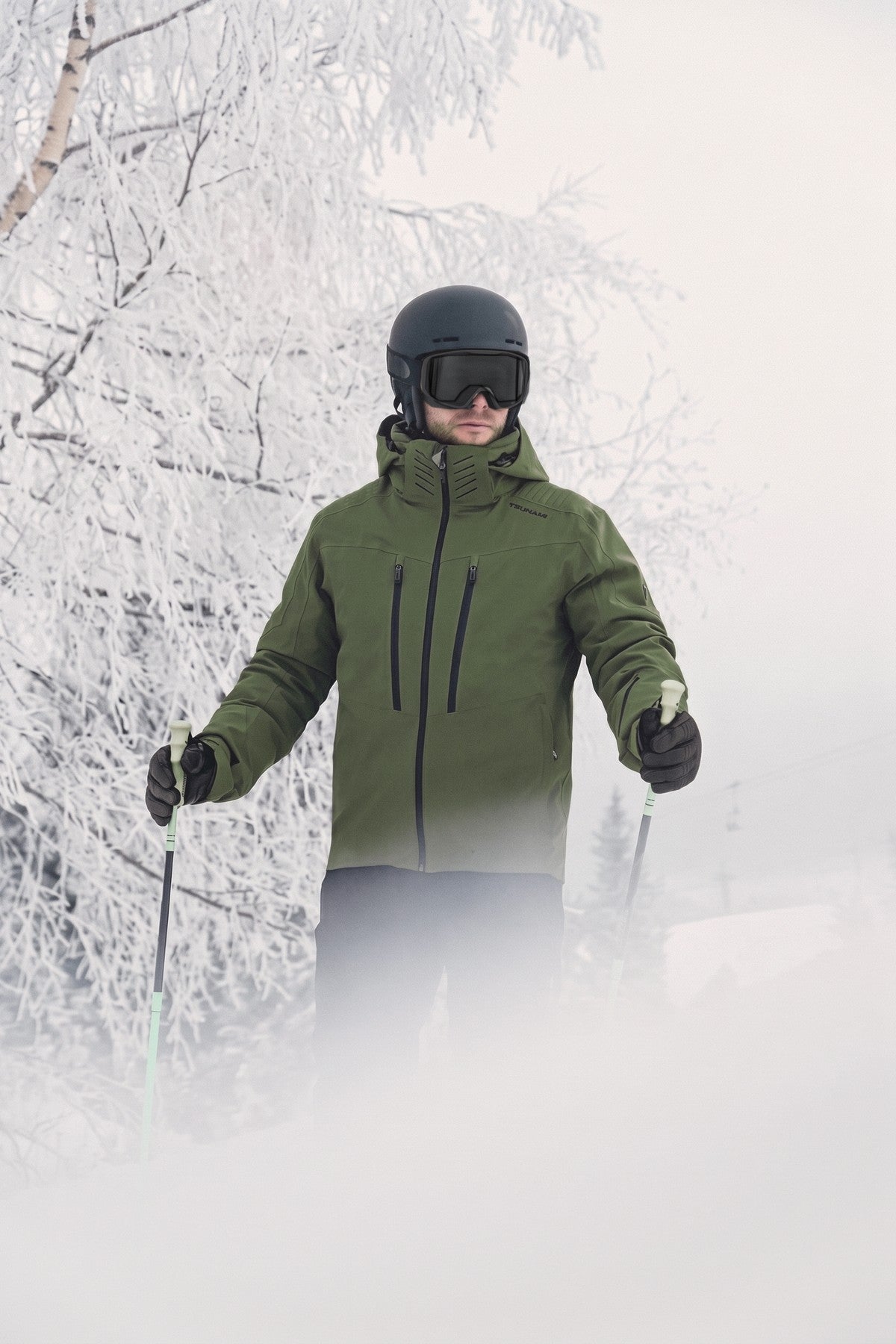 Esquiador con la chaqueta de esquí Tsunami Dominate Kaki en la montaña nevada